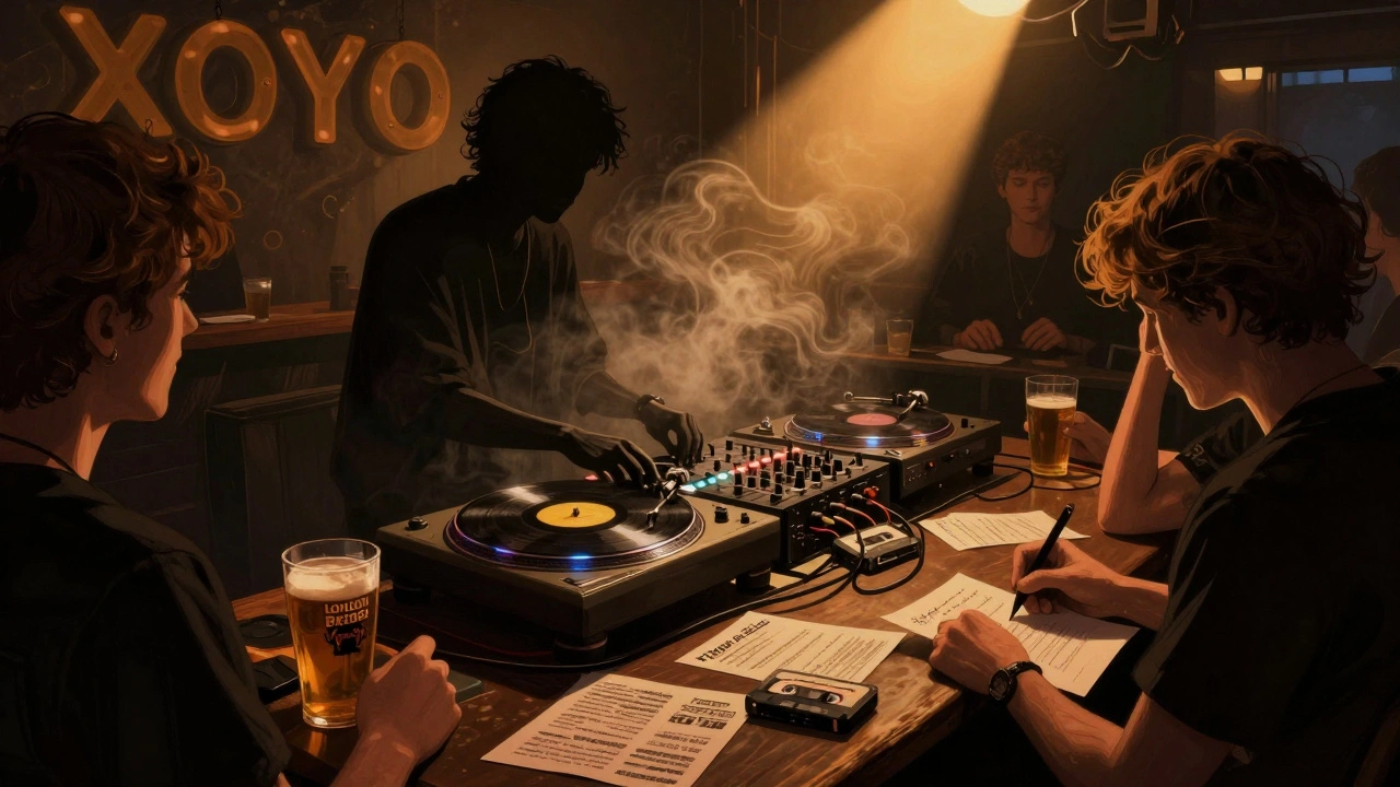 DJ behind vinyl turntables at XOYO, surrounded by flickering lights and music-loving patrons.