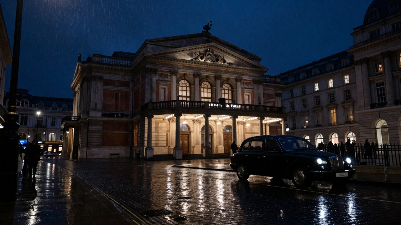 Illuminated Royal Opera House at night with rain on the street nearby.